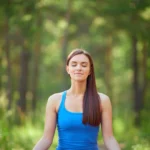 une femme médite au milieu de la nature
